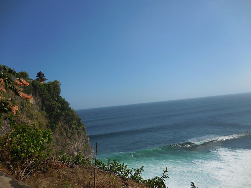 The sea temple of Pura Luhur Uluwatu, its tiered meru shrine perched on a sheer limestone cliff above the surf at the southern tip of Bali
