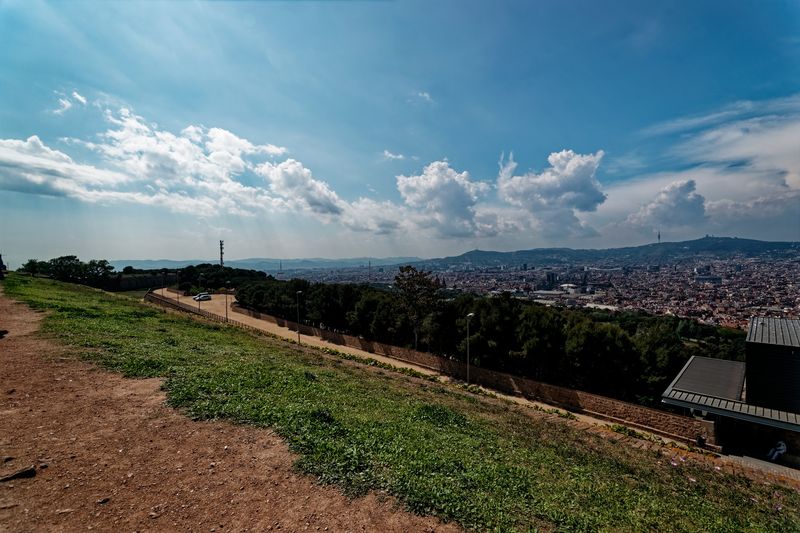 The city of Barcelona spread out below the green hill of Montjuïc, seen from beside its hilltop castle