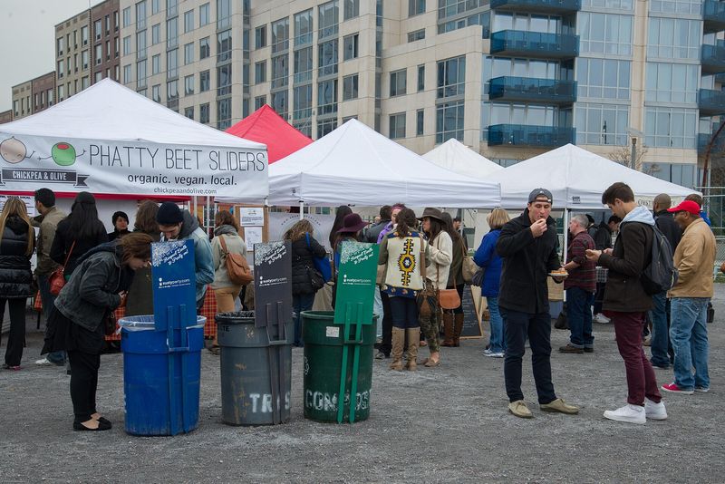 White vendor tents and crowds grazing at the Smorgasburg open-air food market on the Brooklyn waterfront, New York City