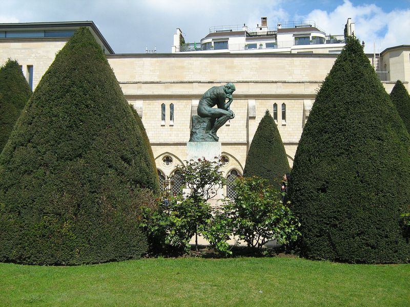 Auguste Rodin's bronze The Thinker on its pedestal among clipped topiary in the garden of the Musée Rodin, Paris