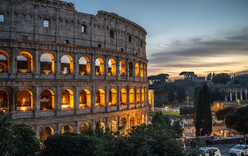 The Colosseum illuminated against a dusk sky in Rome