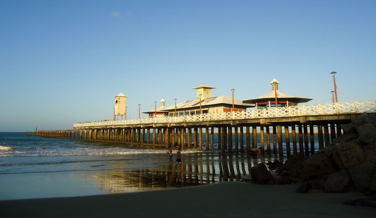The Ponte dos Ingleses iron pier at Praia de Iracema in Fortaleza, seen at low tide over the exposed rocks at its base