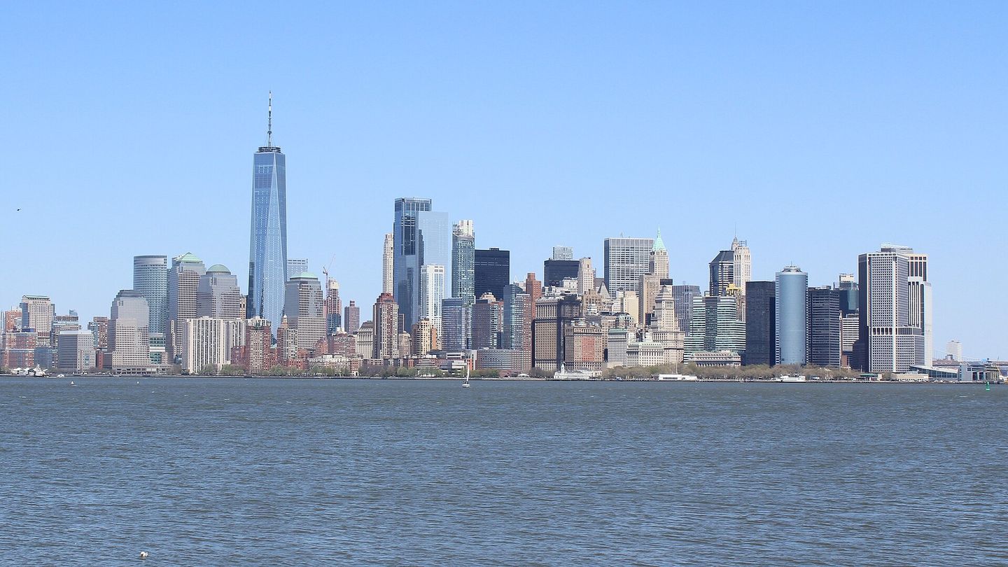 The Lower Manhattan skyline with One World Trade Center rising above the harbor, seen from Liberty Island